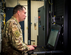solider in server room reviewing information on terminal