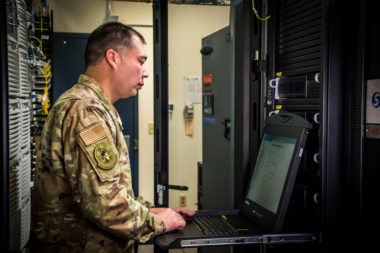 solider in server room reviewing information on terminal